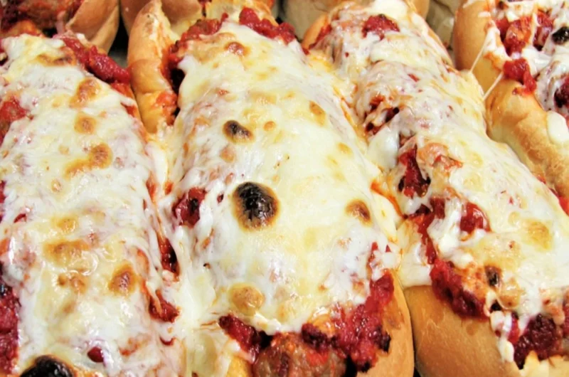 Oven baked meatball sandwiches served on crusty bread with melted cheese