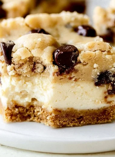 Delicious chocolate chip cheesecake bars with a creamy topping and chocolate chips